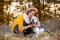 A senior woman with a dog in an autumn nature at sunset. Royalty Free Stock Photo