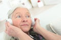 Happy senior woman enjoying music with headphone at home Royalty Free Stock Photo