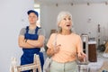 Happy senior woman evaluating quality of work did by teenage boy in building site