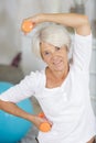 Happy senior woman exercising with dumbbells and smiling at camera Royalty Free Stock Photo