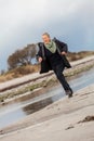 Happy senior woman frolicking on the beach