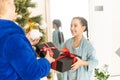 Happy senior woman giving christmas surprise to little girl at home. Excited granddaughter unpacking present under Royalty Free Stock Photo