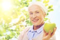 Happy senior woman with green apple at home Royalty Free Stock Photo