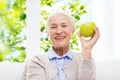 Happy senior woman with green apple at home Royalty Free Stock Photo