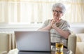 Happy senior woman having video call on laptop at home. Royalty Free Stock Photo