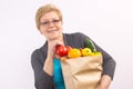 Happy senior woman holding fruits and vegetables in shopping bag, healthy nutrition in old age Royalty Free Stock Photo