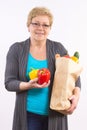 Happy senior woman holding fruits and vegetables in shopping bag, healthy nutrition in old age Royalty Free Stock Photo