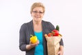 Happy senior woman holding fruits and vegetables in shopping bag, healthy nutrition in old age Royalty Free Stock Photo