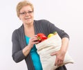 Happy senior woman holding shopping bag with fruits and vegetables, healthy nutrition in old age Royalty Free Stock Photo