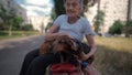 Happy senior woman holds a small dachshund dog in her arms, smiles hugs, presses and shows love to her pet on a bench in