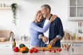 Happy senior woman hugging her husband, cooking dinner Royalty Free Stock Photo