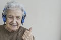 Happy senior woman listening music with headphones