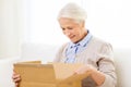 Happy senior woman with parcel box at home Royalty Free Stock Photo