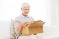 Happy senior woman with parcel box at home Royalty Free Stock Photo