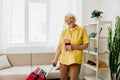 Happy senior woman with passport and travel ticket packed a red suitcase, vacation and health care.