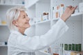 Happy senior woman, pharmacist and inventory on shelf for inspection or checking stock at drugstore. Mature female Royalty Free Stock Photo