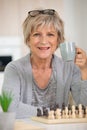 happy senior woman playing chess