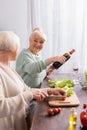 happy senior woman pouring red wine Royalty Free Stock Photo