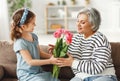 Happy senior woman receiving flowers from granddaughter Royalty Free Stock Photo
