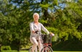 Happy senior woman riding bicycle at summer park Royalty Free Stock Photo