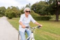 Happy senior woman riding bicycle at summer park Royalty Free Stock Photo