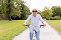 Happy senior woman riding bicycle at summer park Royalty Free Stock Photo