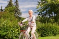 Happy senior woman riding bicycle at summer park Royalty Free Stock Photo