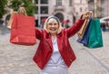 Happy senior woman shopaholic consumer after shopping sale with full bags walking in city street Royalty Free Stock Photo