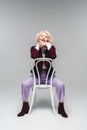 happy senior woman sitting on chair and looking at camera Royalty Free Stock Photo