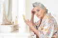 Happy senior woman sitting near dressing table Royalty Free Stock Photo