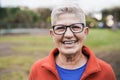 Happy senior woman smiling on camera outdoor in city park - Focus on face Royalty Free Stock Photo