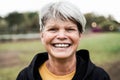 Happy senior woman smiling on camera outdoor in city park - Focus on face Royalty Free Stock Photo