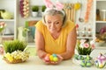 Happy senior woman wearing rabbit ears preparing to Easter