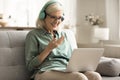 Happy senior woman in wireless earphones talking on video call Royalty Free Stock Photo