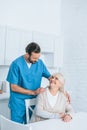 happy senior woman and young caregiver smiling