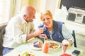 Happy seniors couple eating pancakes in a bar restaurant - Retired people having fun enjoying lunch together Royalty Free Stock Photo