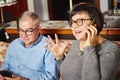 Happy seniors couple sitting on the couch while woman talking on the phone. Royalty Free Stock Photo