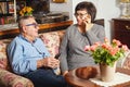 Happy seniors couple sitting on the couch while woman talking on the phone. Royalty Free Stock Photo