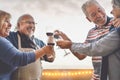 Happy seniors friends drinking red wine on terrace sunset - Mature people having fun laughing and sharing time together outdoor