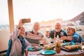 Happy seniors friends taking selfie with mobile smartphone camera at barbecue dinner