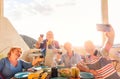 Happy seniors taking a selfie with mobile phone and making a barbecue on the rooftop Royalty Free Stock Photo