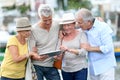 Happy seniors travelling and visiting using tablet