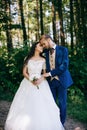 Happy sensual Bride and groom at wedding Day embracing with love. Romantic young couple celebrating their marriage in forest Royalty Free Stock Photo