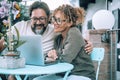 Happy serene couple in love using laptop together at home in the garden smiling and having fun. Man and woman watching computer Royalty Free Stock Photo