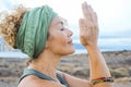 Happy serene woman smile with closed eyes and hands in front of her face and nature landscape scenic in background. Connection