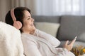 Happy serene young pregnant woman in headphones enjoying relaxing music Royalty Free Stock Photo