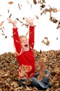 Happy Seven Year Old Girl Playing in Pile of Leaves Royalty Free Stock Photo