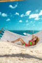 Happy sexy and beautiful woman lying in the hammock on the beach with a wonderful white sand - Image Royalty Free Stock Photo