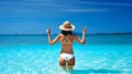 Happy sexy woman in white bikini and straw hat showing peace sign with both hands relax in turquoise sea Royalty Free Stock Photo