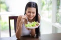 Happy sexy young asian woman in white singlet smiling and eating  fresh organic salad . A beautiful girl have breakfast healthy Royalty Free Stock Photo